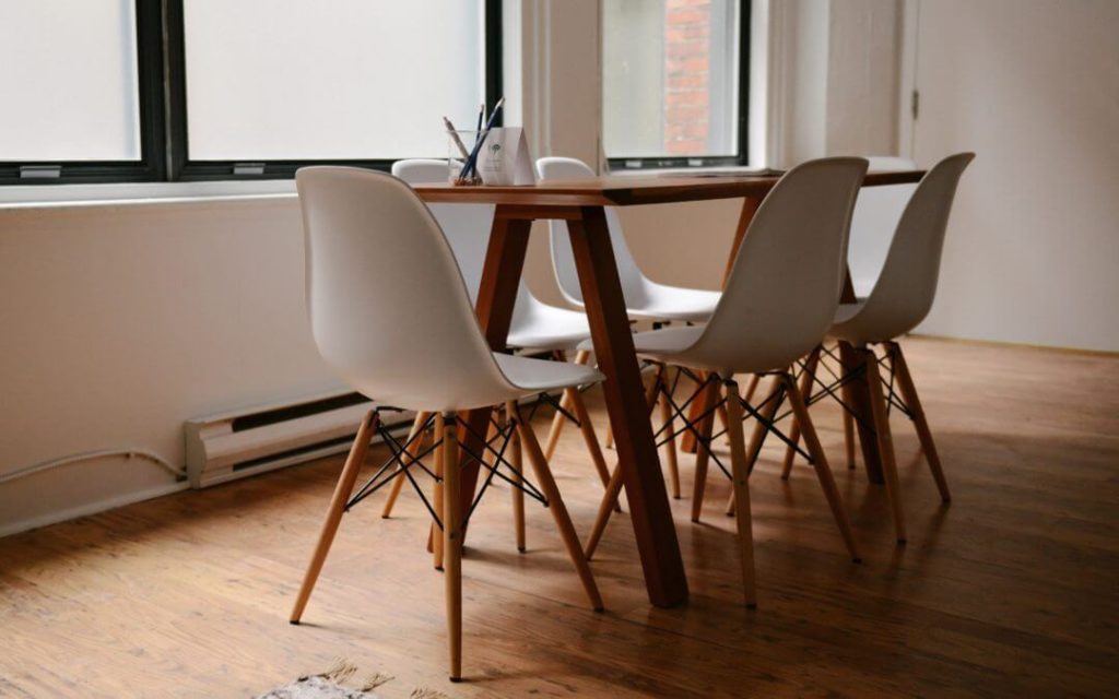 Empty conference table with white chairs