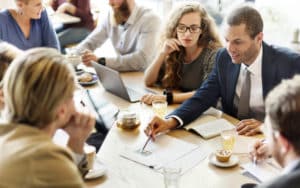 Salespeople sitting around a table, discussing sales strategy