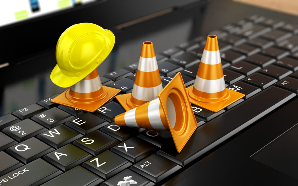 Photo of several tiny traffic cones blocking access to a computer keyboard