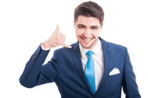 Cheesy image of man with braces holding his hand up in a "phone" formation next to his head